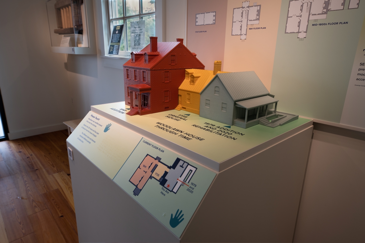 A 3D model of Woodlawn House includes a three-story red section on the left, a two-story yellow section at the center, and a two-story blue section on the right.